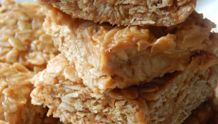 A close-up of several no bake peanut butter oatmeal bars stacked on top of each other.