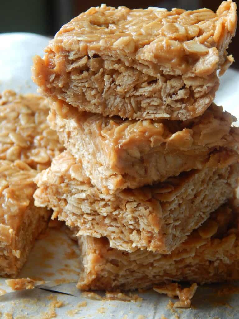 A close-up of several no bake peanut butter oatmeal bars stacked on top of each other.