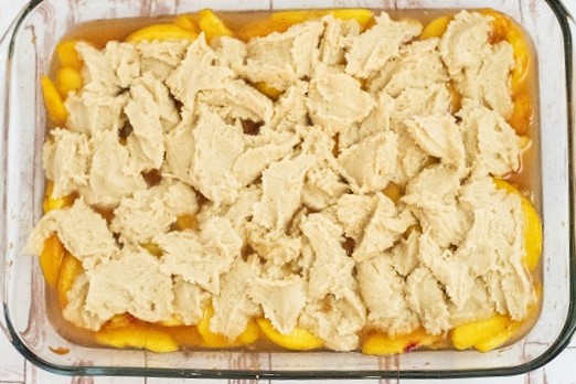 Peach filling topped with unbaked dough spread across the top 