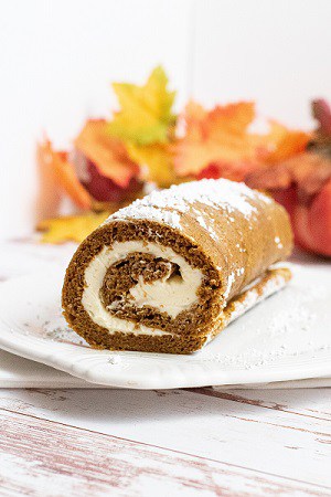 a pumpkin roll with pumpkins in the back ground. 