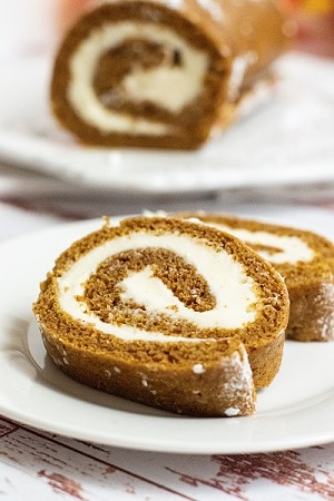 two slices of pumpkin roll on a white plate. 