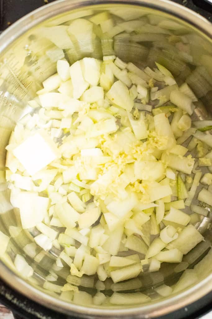 Diced onions and garlic in the bottom of an instant pot.