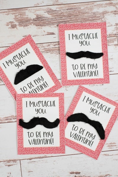 4 mustache valentines on a white wooden background 