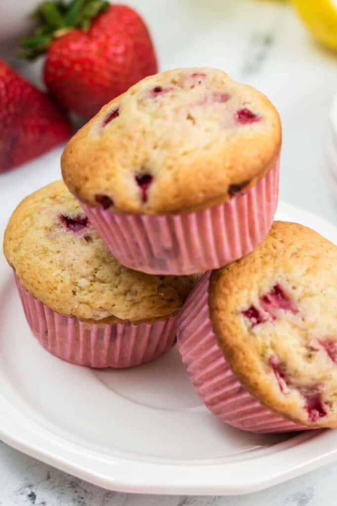 A close up of 3 muffins on a plate. 