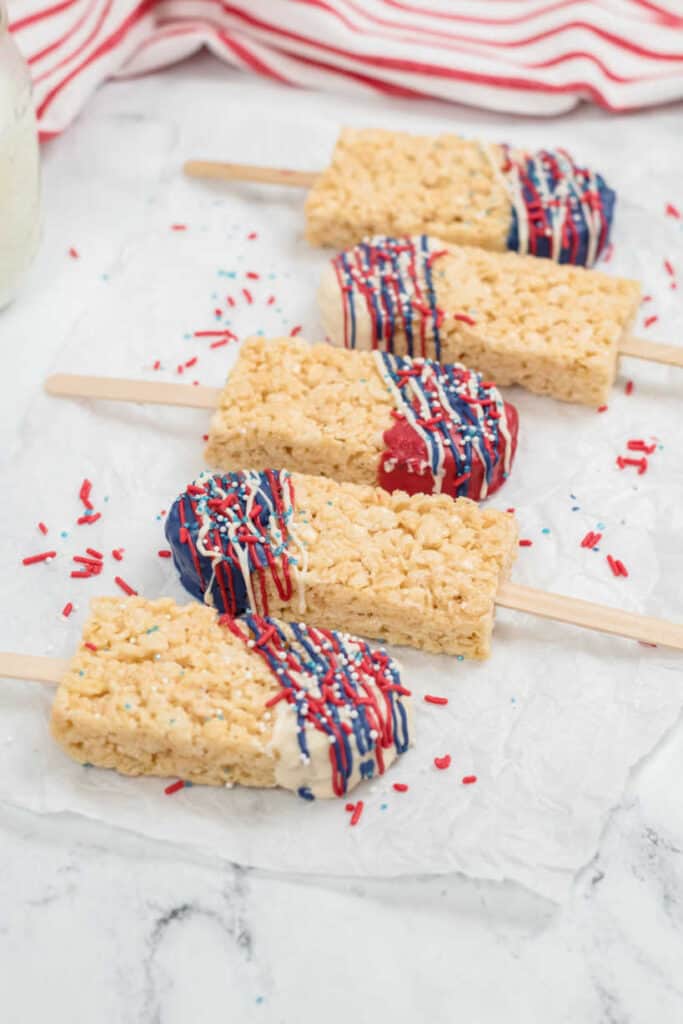Popsicle shaped Rice Krispies Treats laid on a piece of wax paper 