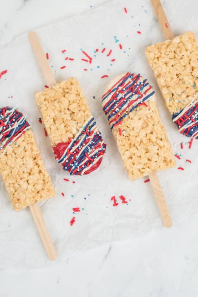 Red white and blue rice krispies pops arranged on wax paper 