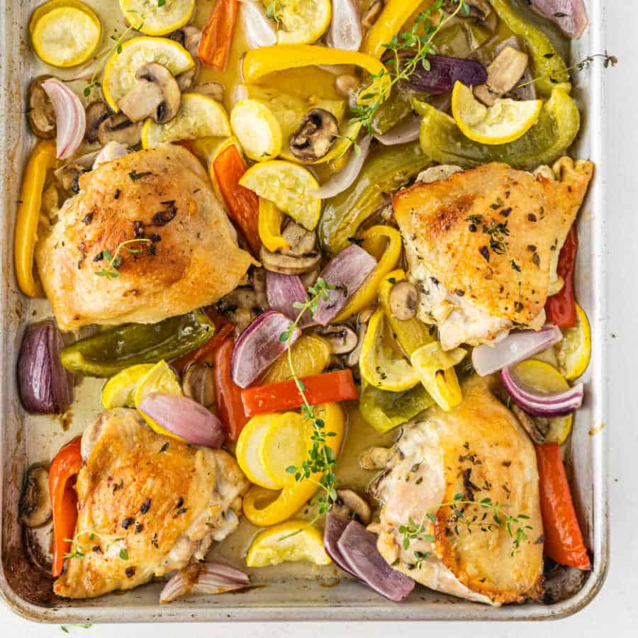 A baking sheet with roasted chicken and vegetables 