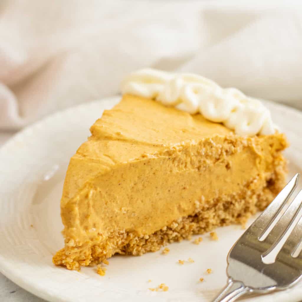 A piece of no bake pumpkin cheesecake on a white plate 
