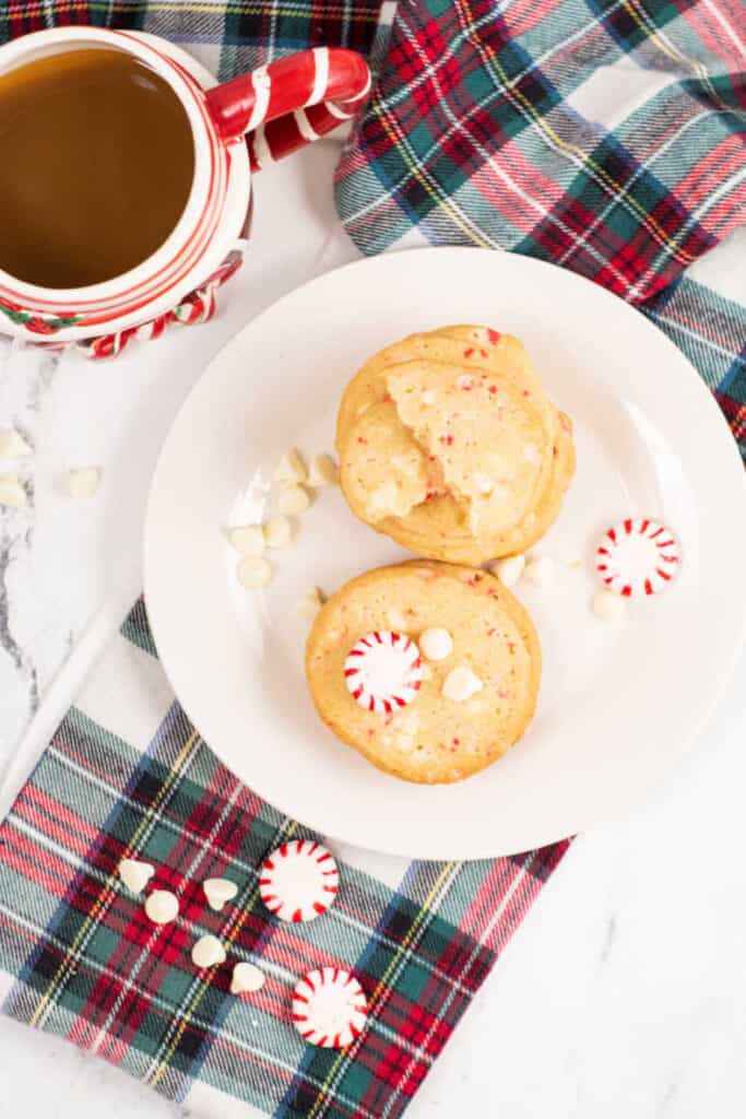 Peppermint bark cookies on a white plate with a coffee mug. 