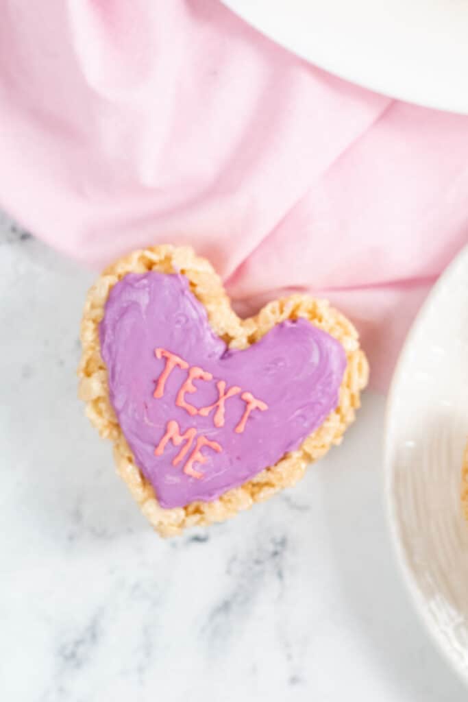A purple rice krispie treat conversation heart that says "Text Me" 