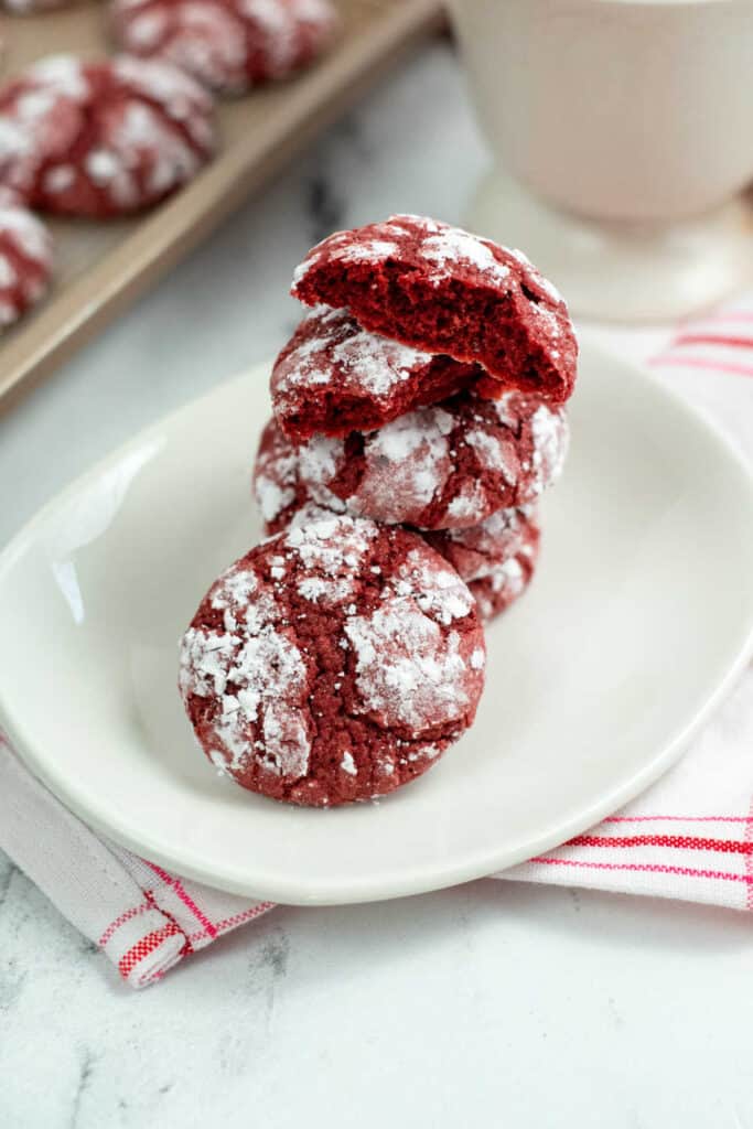 A stack of red velvet crinkle cookies on a white plate