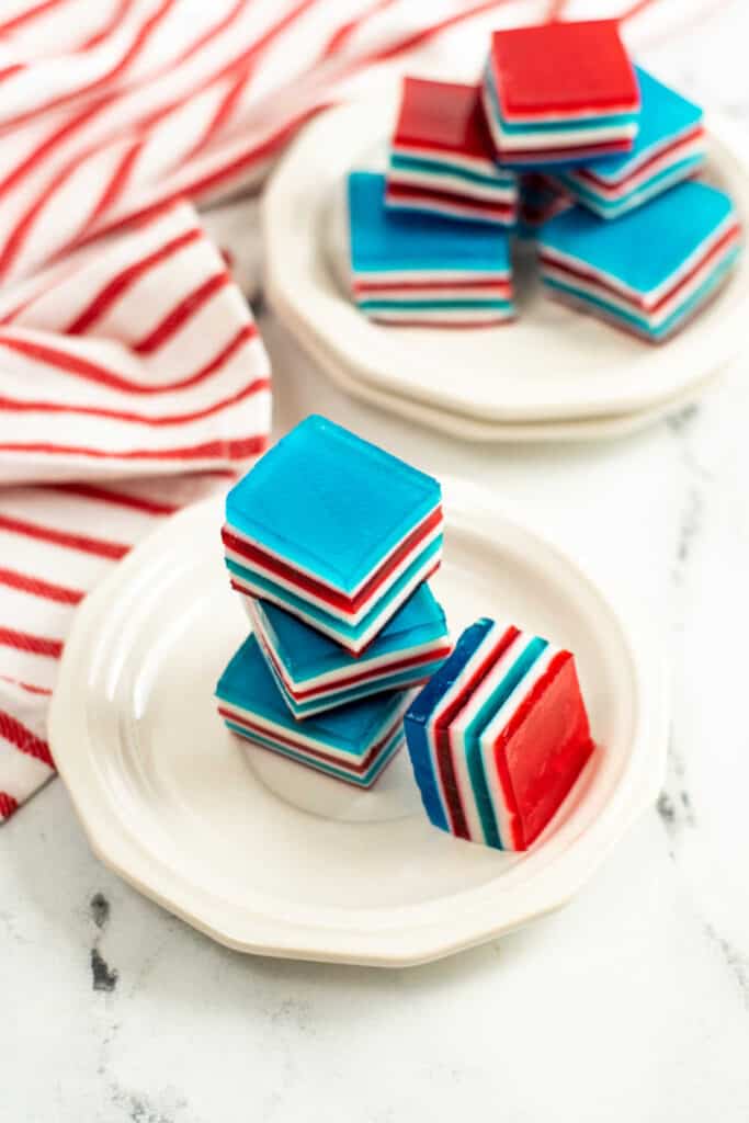 Red white and blue Jell-o squares on a white plate. 
