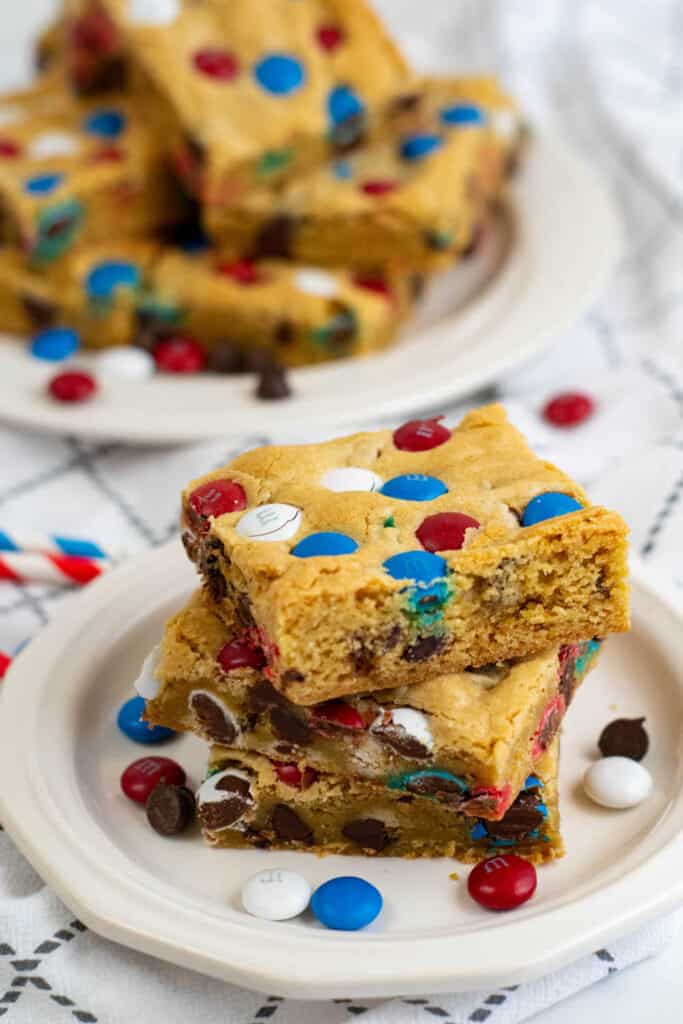 A pile of cookie bars on a white plate. 