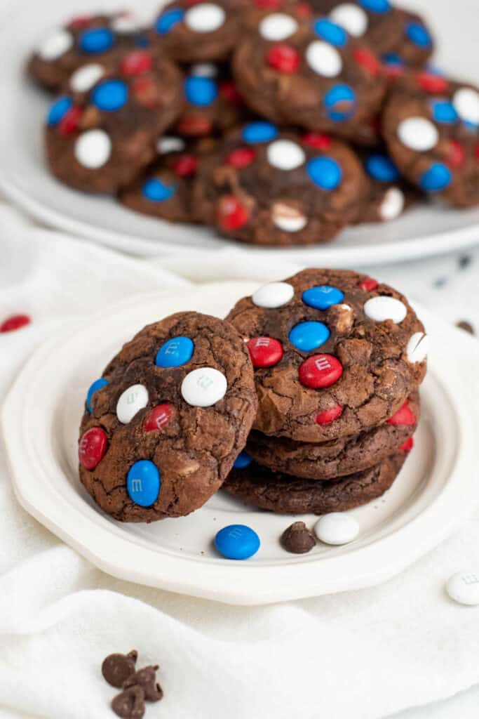 A stack of brownie cookies on a white plate 