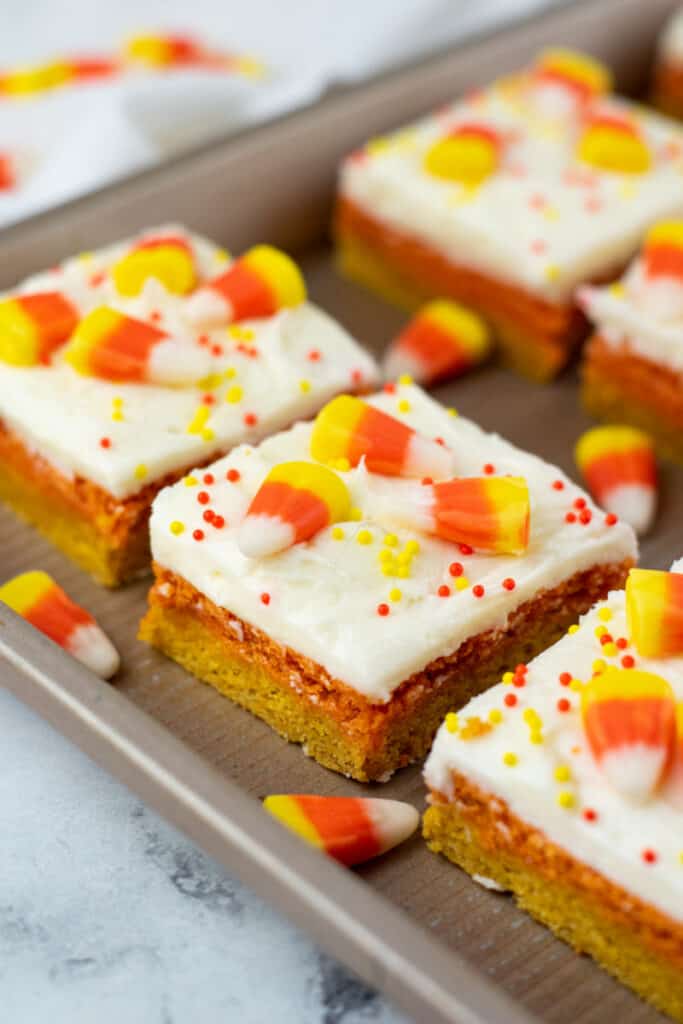 A close up of a frosted candy corn cookie bar. 