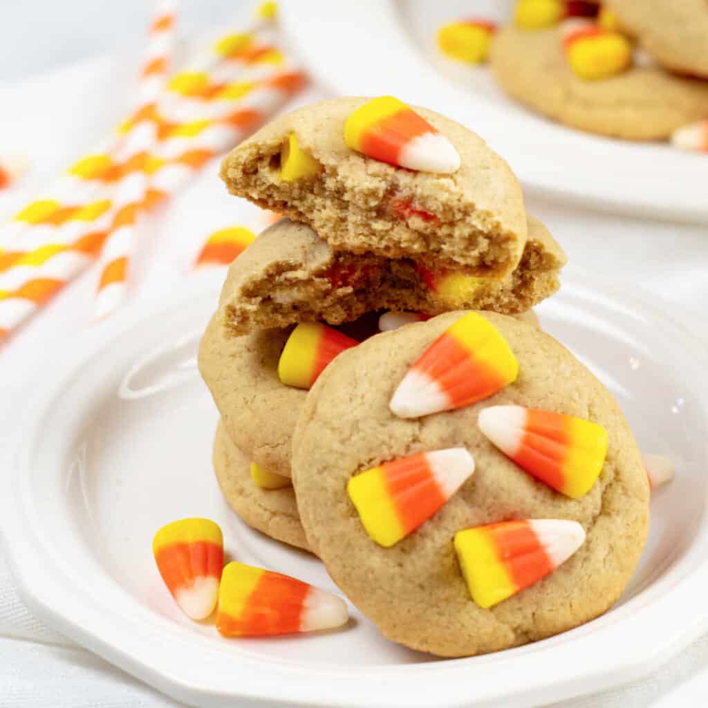 A stack of candy corn cookies on a white plate. 