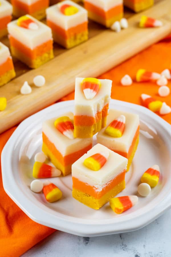a stack of candy corn fudge on a white plate. 