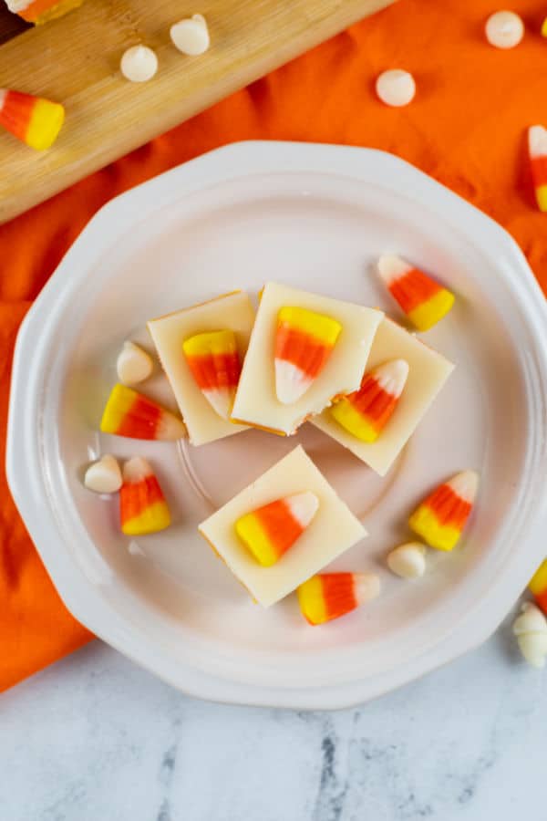 An overhead shot of candy corn fudge on a white plate. 