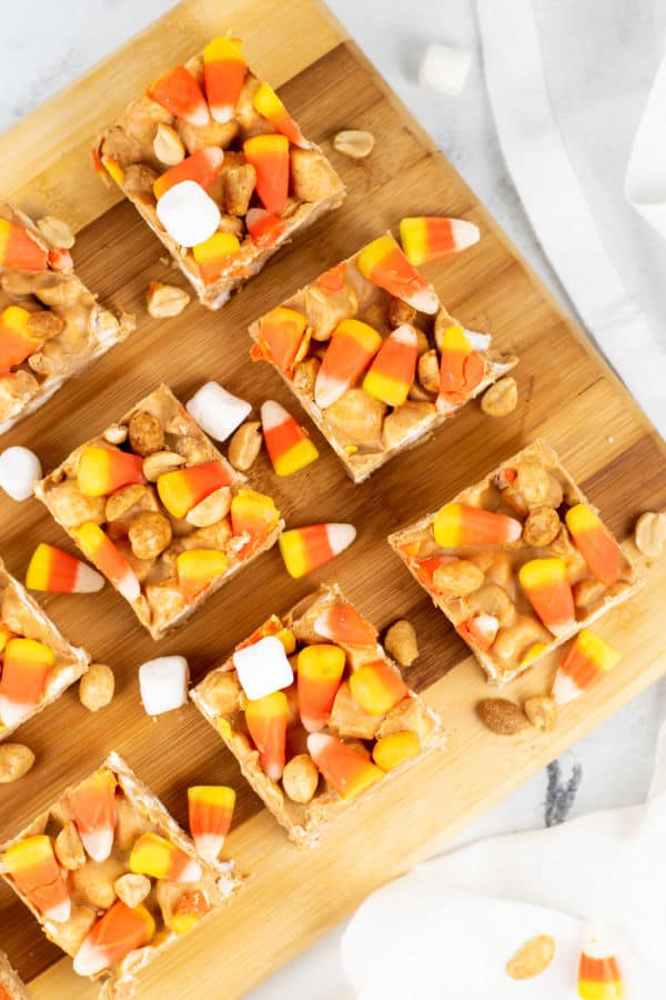 Marshmallow peanut candy corn squares on a wooden chopping block 