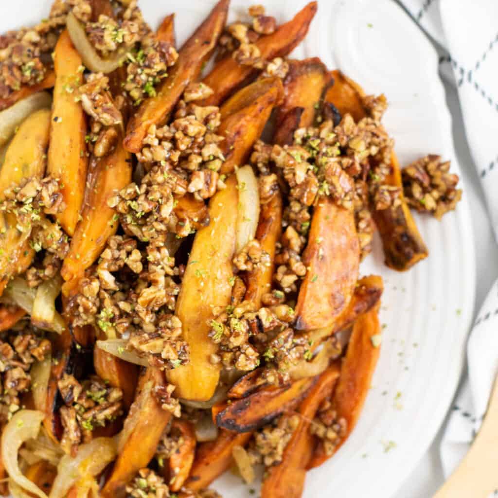 A close up of roasted sweet potatoes with a pecan topping.
