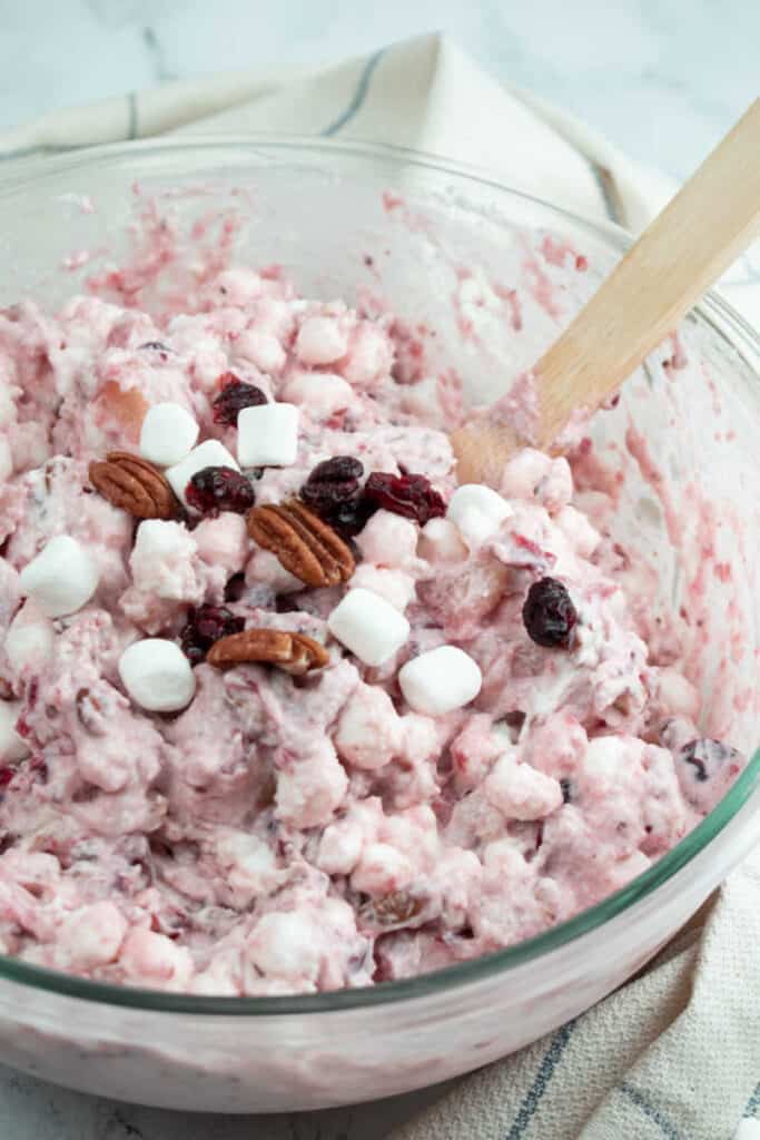 a clear glass bowl full of creamy cranberry salad. 