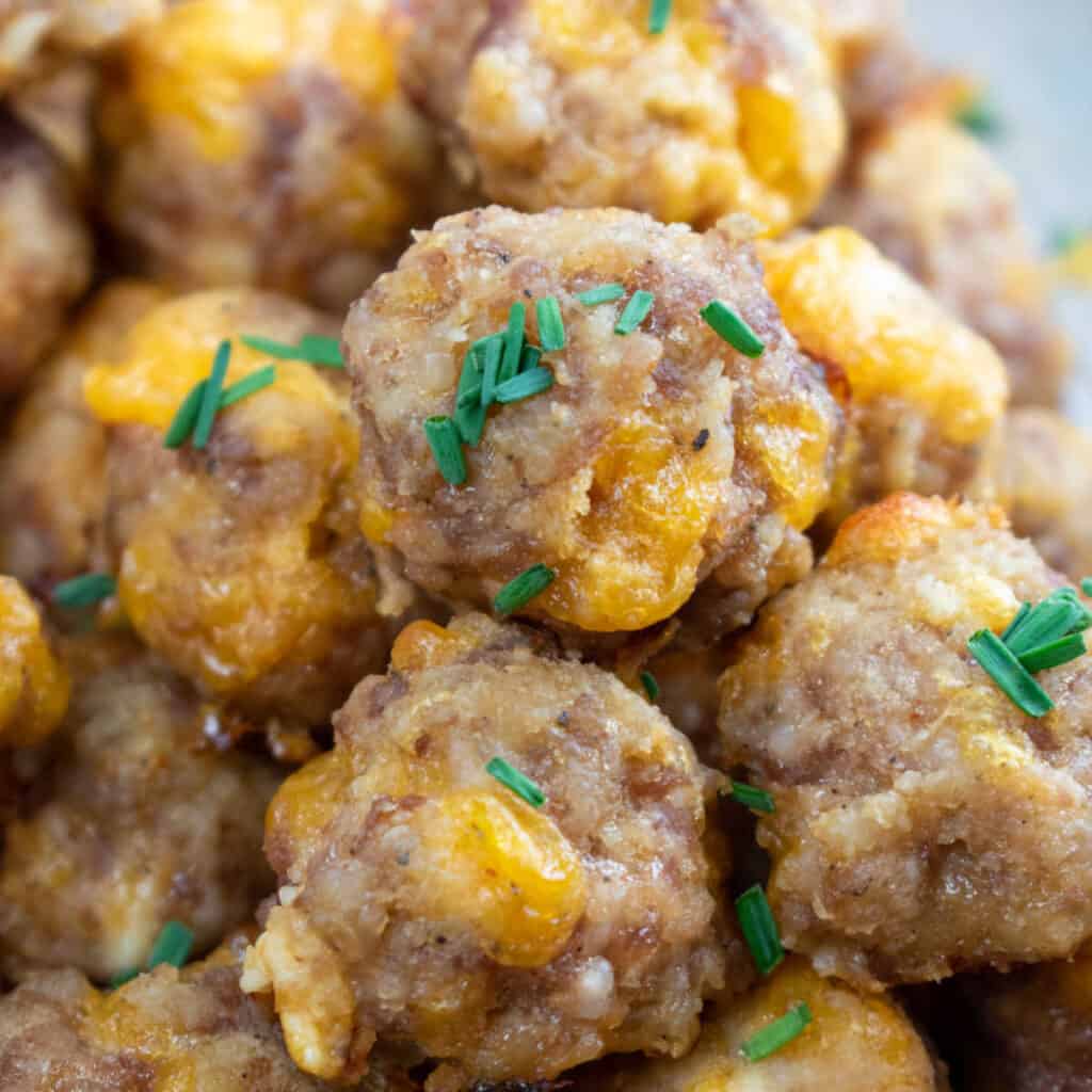 a close up of sausage balls with fresh chives on them. 