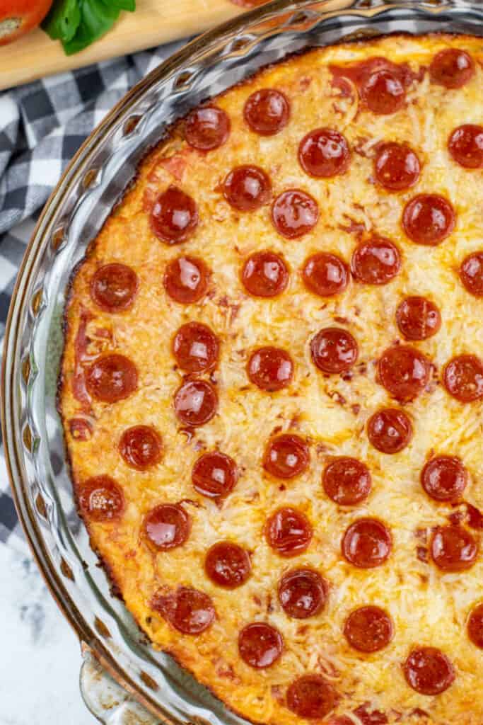 A close up of a pizza dip in a glass pie plate. 