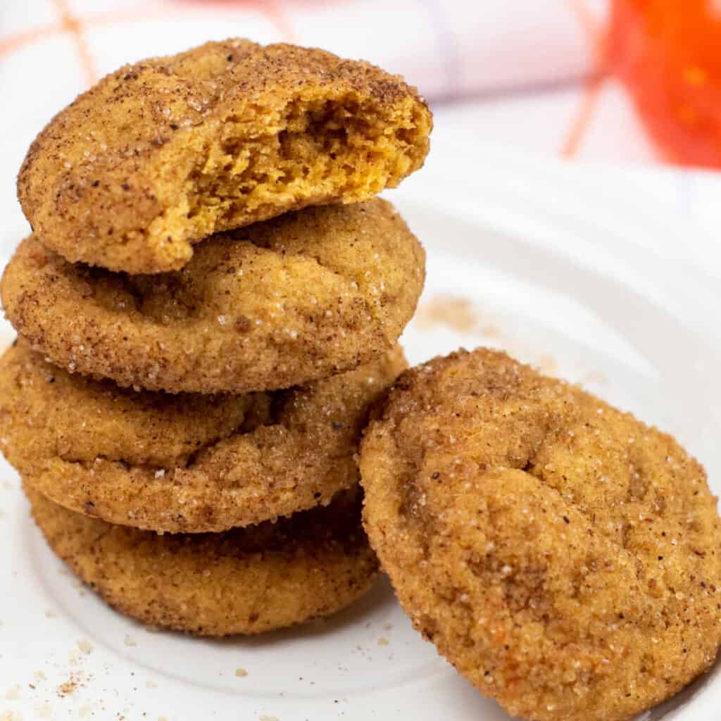 A stack of pumpkin snickerdoodle cookies on a white plate. 