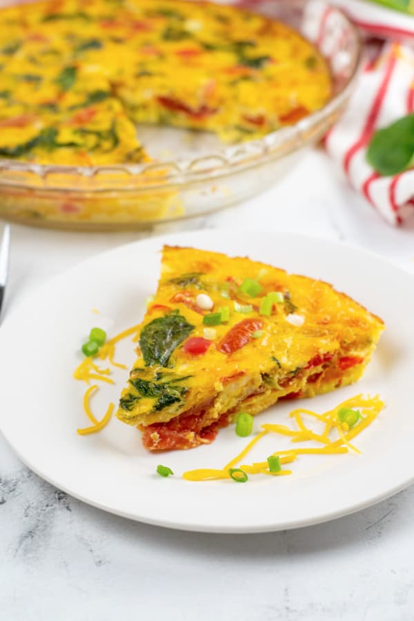 A piece of vegetable frittata on a white plate. 