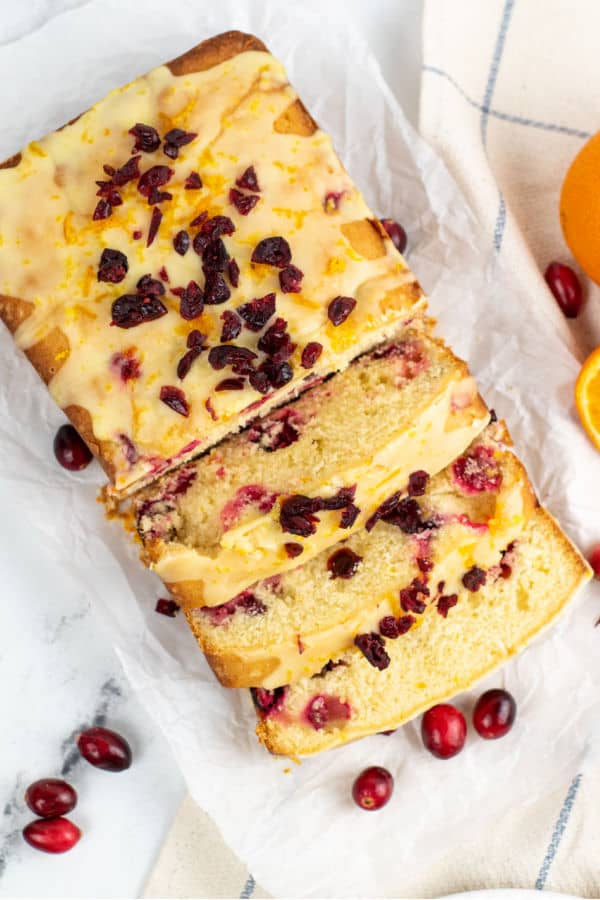 An overhead shot of a loaf of orange cranberry pound cake that has been sliced. 
