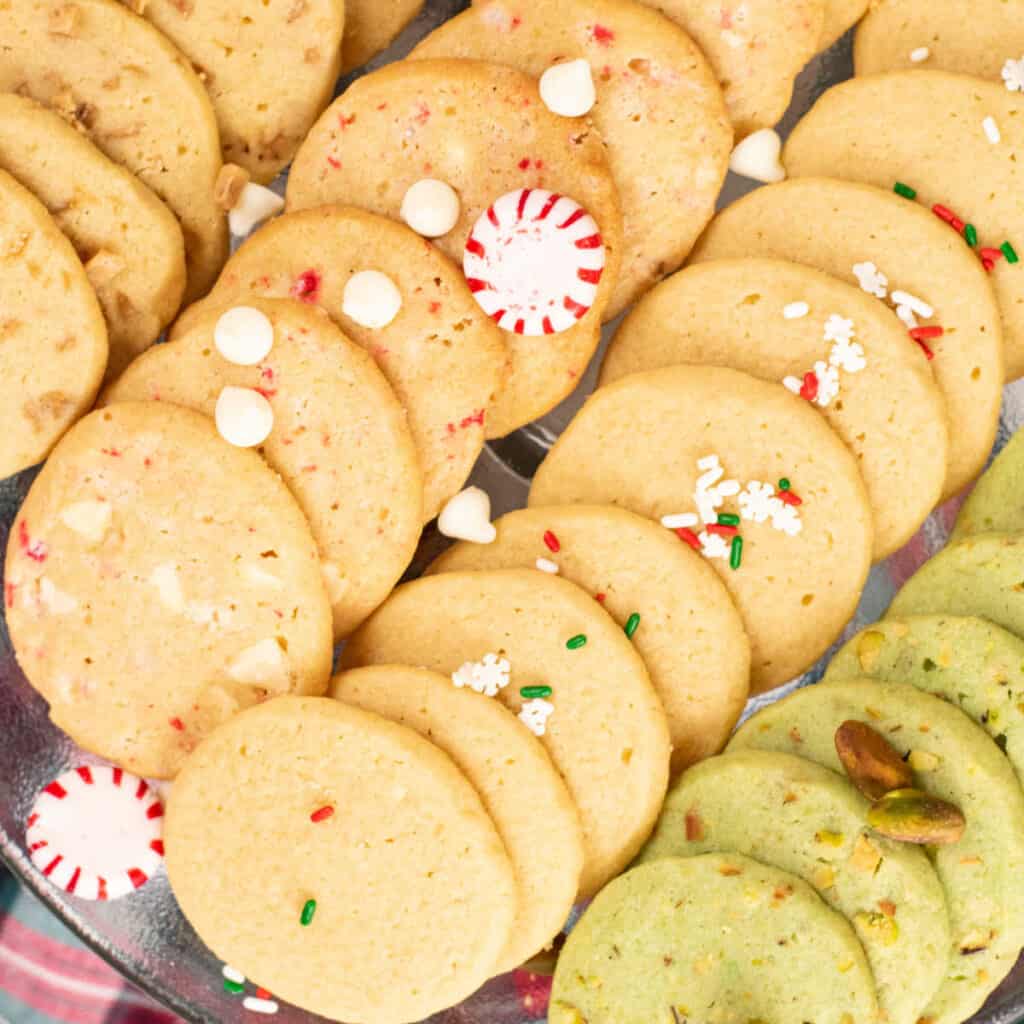 A close up of four varieties of icebox cookies.  Pistachio, sugar, peppermint bark and toffee. 