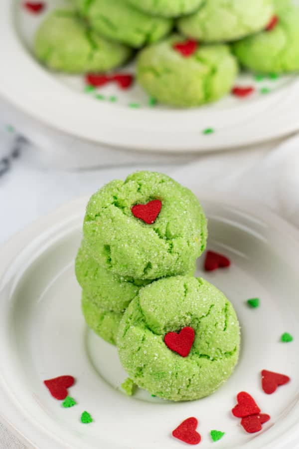 A stack of green Grinch crinkle cookies on a white plate. 