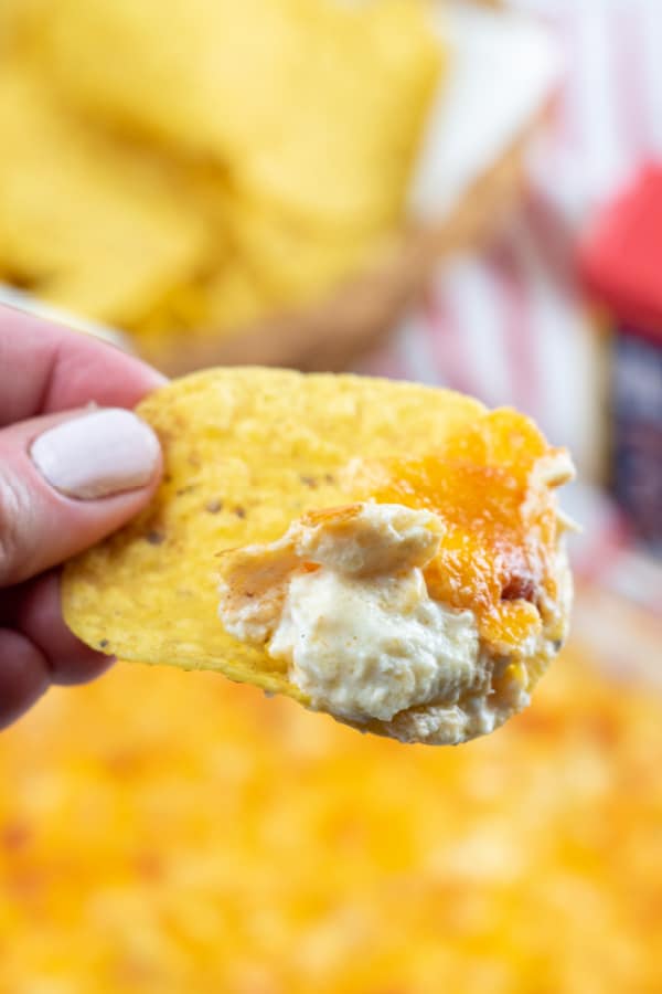 a corn tortilla chip with cheesy crab dip on it. 