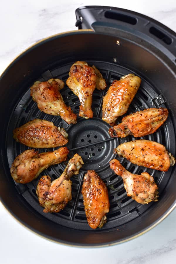 Chicken wings in an air fryer basket, 