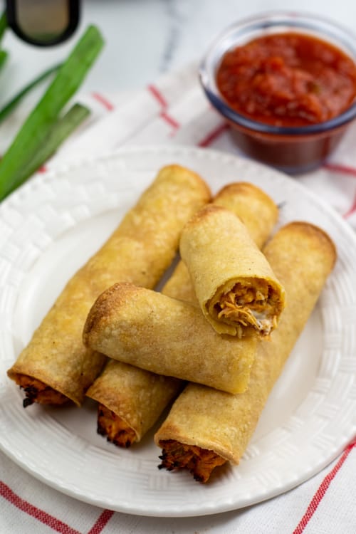 A small white plate of air fryer chicken taquitos.