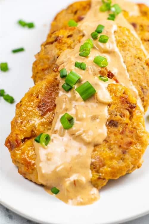 A white plate of chicken bacon ranch patties topped with a creamy sauce.