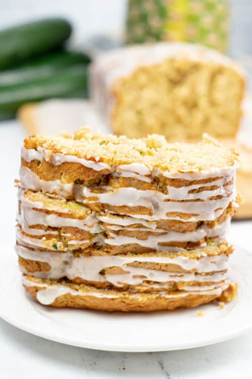 A stack of pineapple zucchini bread slices on a white plate.