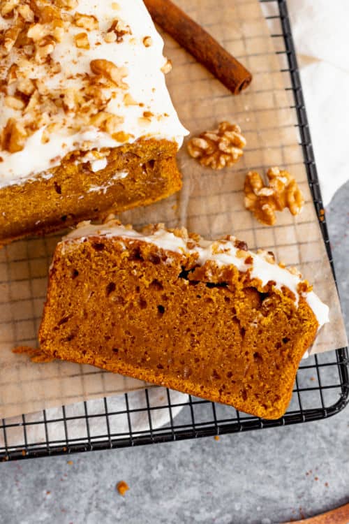 An overhead view of a slice of pumpkin bread with cream cheese icing.