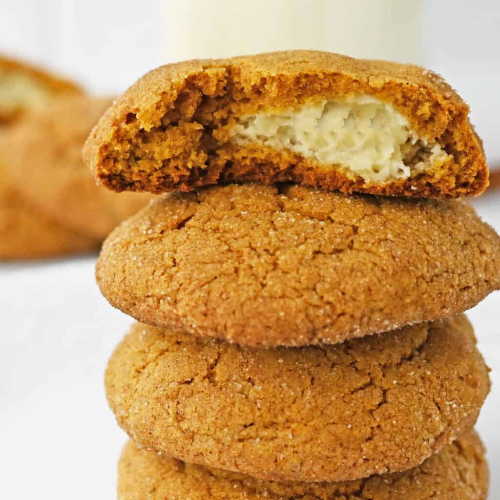 A close-up of several pumpkin cheesecake cookies stacked on top of each other.