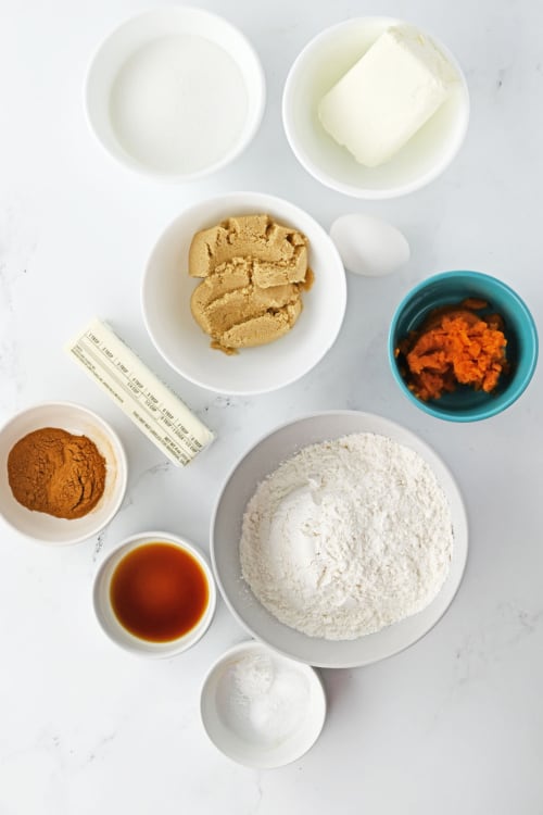 An overhead view of several ingredients for pumpkin cheesecake cookies.