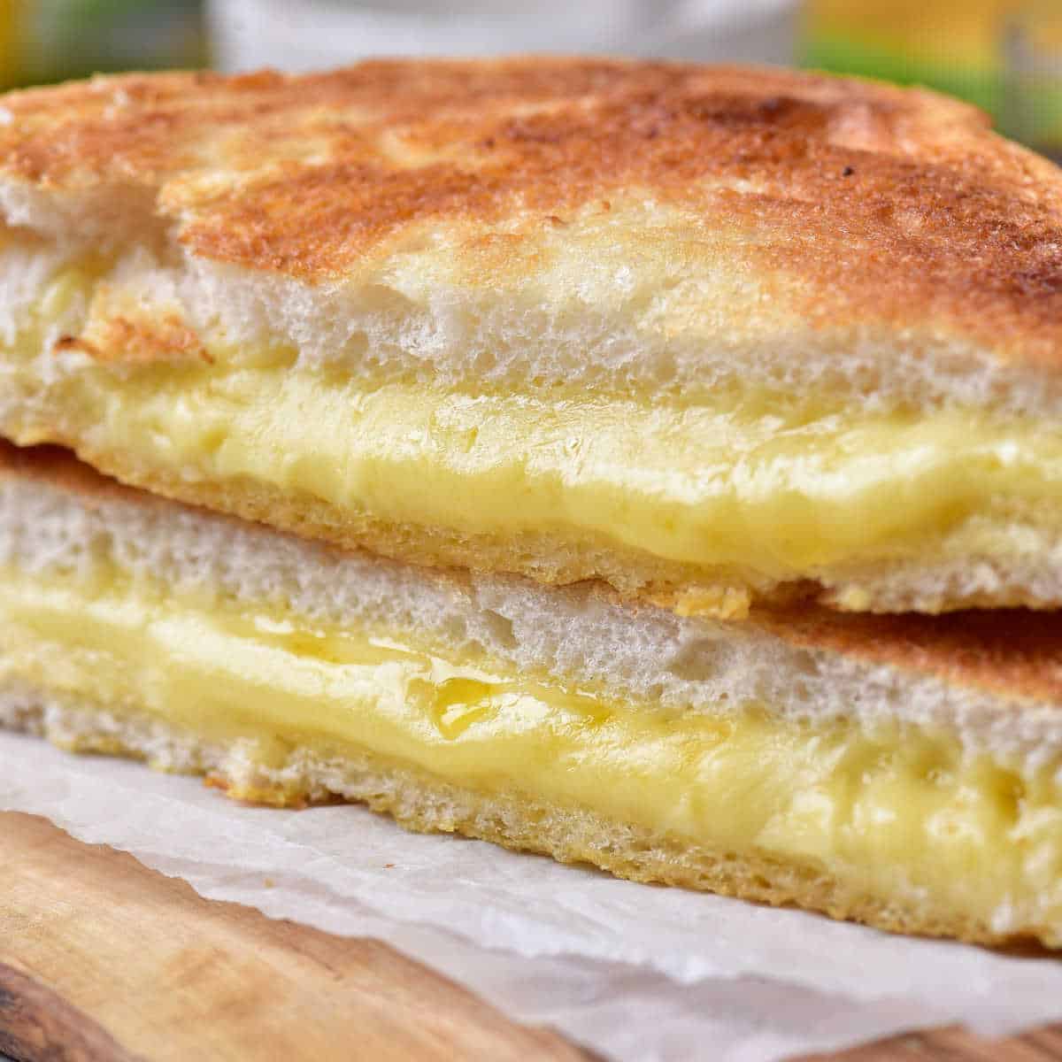 A close up of the melted cheese in the center of a air fryer grilled cheese sandwich.