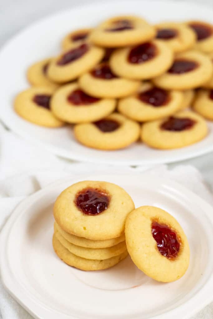 A plate with a stack of thumbprint cookies