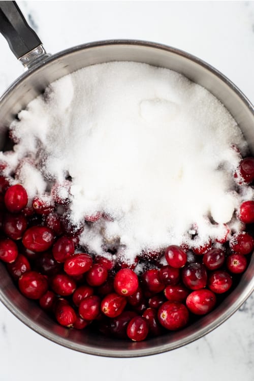 a pot with cranberries, sugar liquid in it