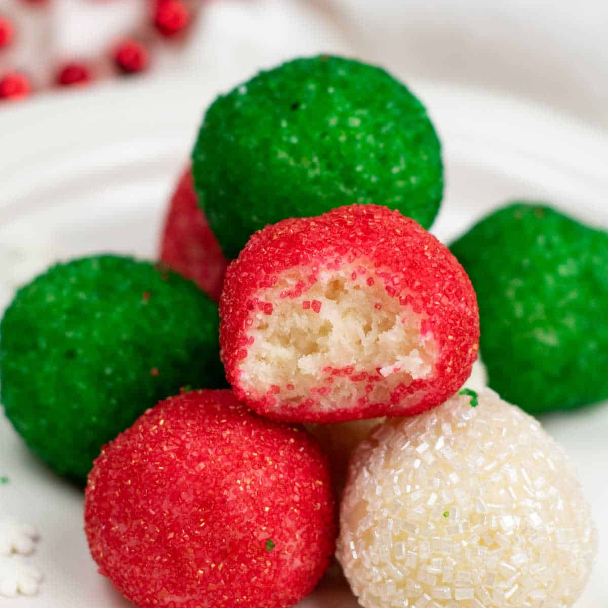 A close up of no bake Christmas truffles covered in red, green and white sanding sugar.
