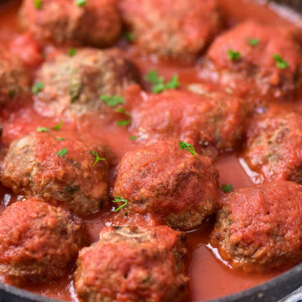 A close up of a pan of meatballs covered in sauce