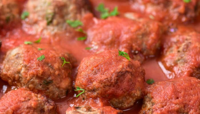 A close up of a pan of meatballs covered in sauce