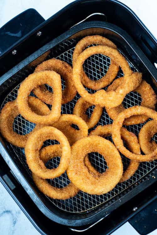 an air fryer full of frozen onion rings