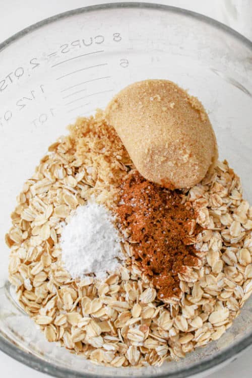Oatmeal, brown sugar, baking soda and cinnamon in a glass mixing bowl