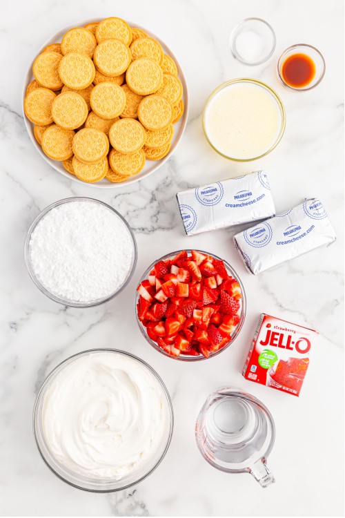 The ingredients for strawberry delight on a white marble background.