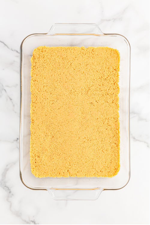 a glass rectangular baking dish with a graham cracker crust in the bottom.